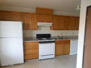 366 Quail Way Fallon, NV 89406 - Photo 8 of 18 a kitchen with granite countertop a stove and a refrigerator
