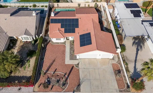 an empty room with chandelier fan and windows