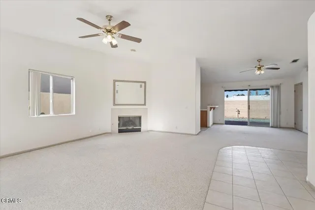 a view of an empty room with a fireplace and a window