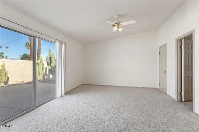a view of an empty room with a chandelier fan