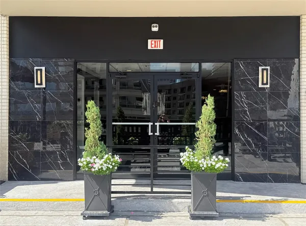 a front view of a house with a yard potted plant and sign