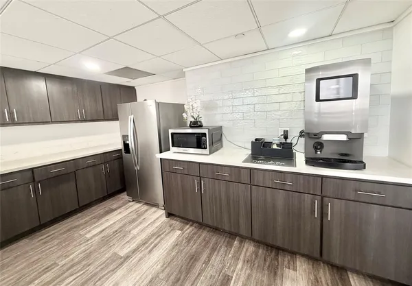 a kitchen with stainless steel appliances granite countertop a refrigerator a sink dishwasher a stove and wooden cabinets