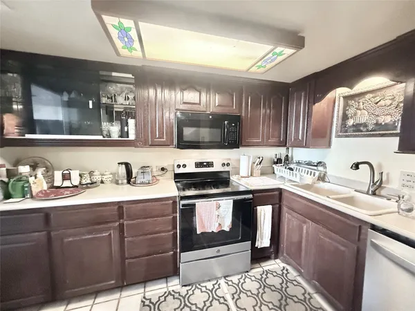 a kitchen with stainless steel appliances granite countertop a sink stove and cabinets