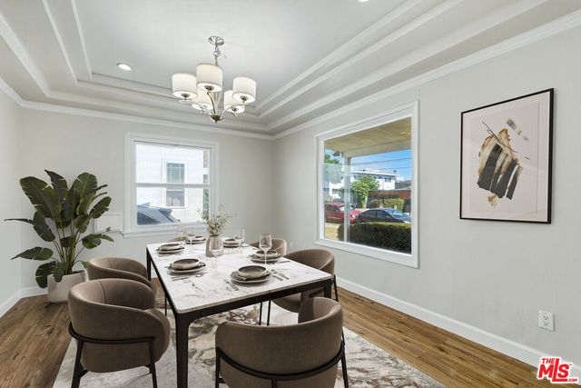 a view of a dining room with furniture a chandelier and wooden floor