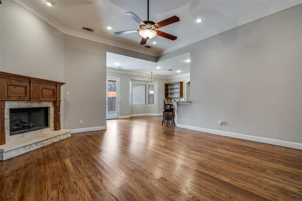 711 Ridgeview Drive Rockwall, TX 75087 - Photo 12 of 39 a view of an empty room with wooden floor a ceiling fan and a kitchen view