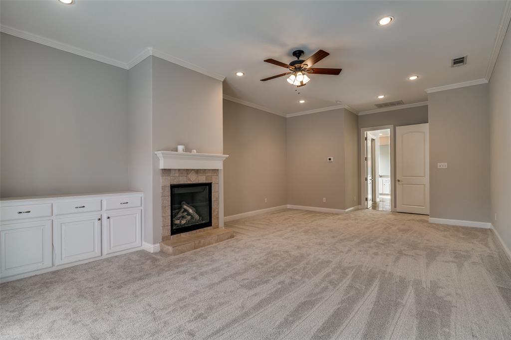711 Ridgeview Drive Rockwall, TX 75087 - Photo 18 of 39 a view of an empty room with a fireplace and chandelier fan
