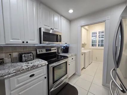 a kitchen with granite countertop a stove a sink and a microwave