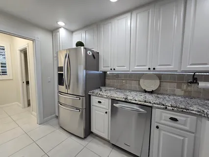 a kitchen with stainless steel appliances granite countertop a refrigerator sink and cabinets