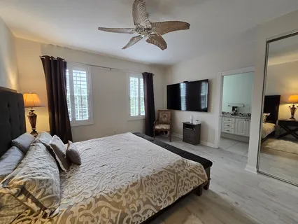 a bathroom with a granite countertop double vanity sink a mirror and a bathtub