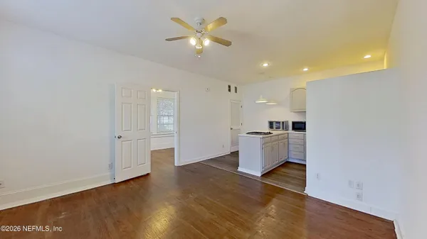 a large kitchen with a refrigerator and white cabinets