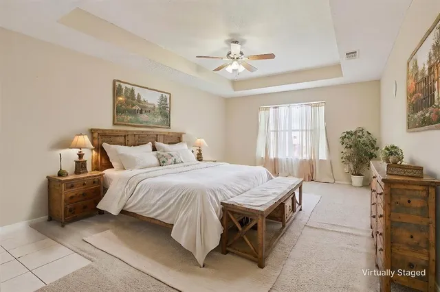 a spacious bedroom with a bed and a chandelier