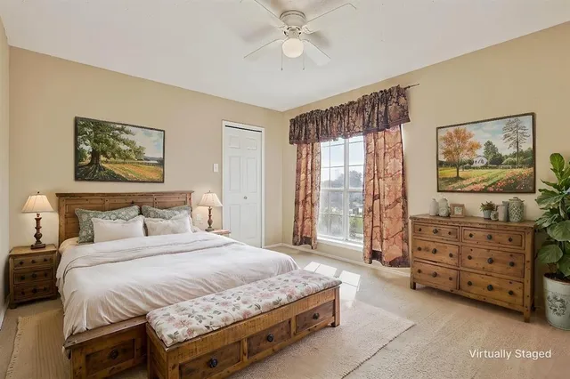 a spacious bedroom with a bed a dresser and a painting on the wall