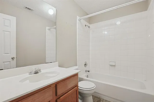 a bathroom with a granite countertop sink a toilet and shower