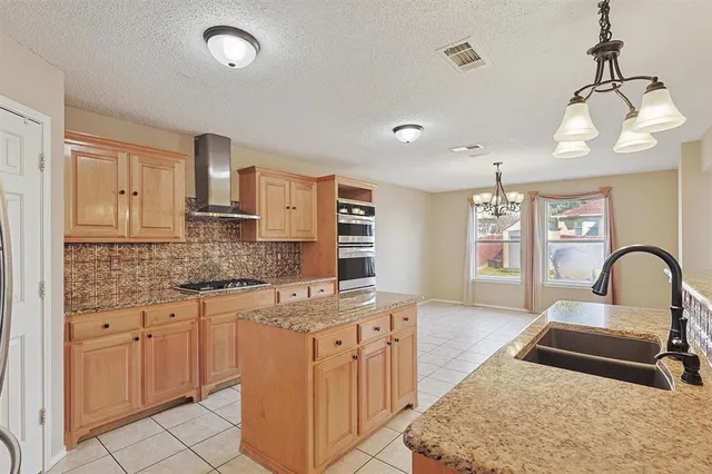 a kitchen with stainless steel appliances granite countertop a sink stove and cabinets