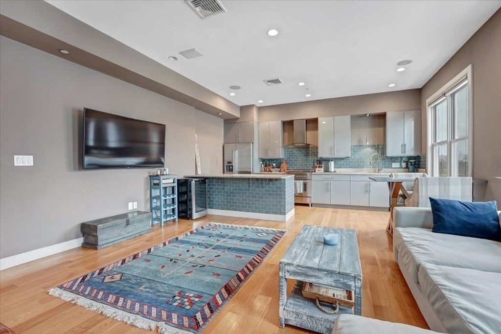 45 Vinton Street, Unit 4 Boston, MA 02127 - Photo 2 of 28 a large kitchen with kitchen island a sink a counter top space and stainless steel appliances