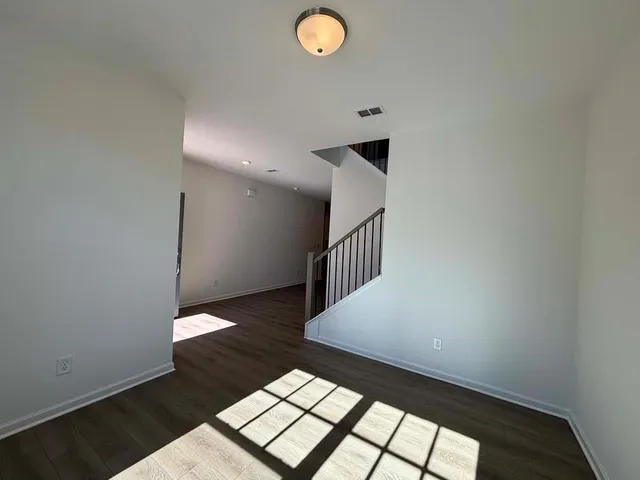 a view of an empty room with wooden floor