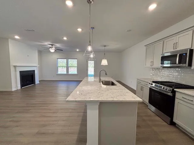 a kitchen with kitchen island a sink stainless steel appliances and cabinets