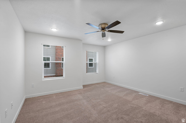 445 950 South Ogden, UT 84404 - Photo 11 of 28 Primary bedroom with light carpet, healthy amount of natural light, and ceiling fan