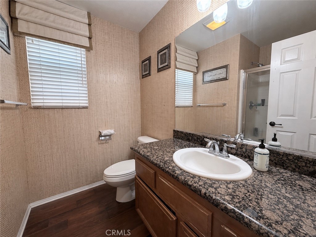 562 Quigley Lane Perris, CA 92570 - Photo 15 of 29 a bathroom with a granite countertop sink toilet and a mirror