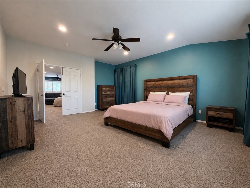 562 Quigley Lane Perris, CA 92570 - Photo 17 of 29 a spacious bedroom with a bed and a chandelier