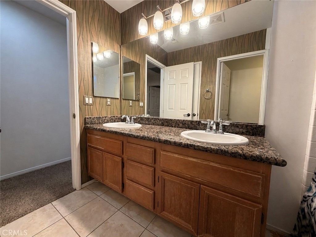 562 Quigley Lane Perris, CA 92570 - Photo 25 of 29 a bathroom with a granite countertop sink and a mirror