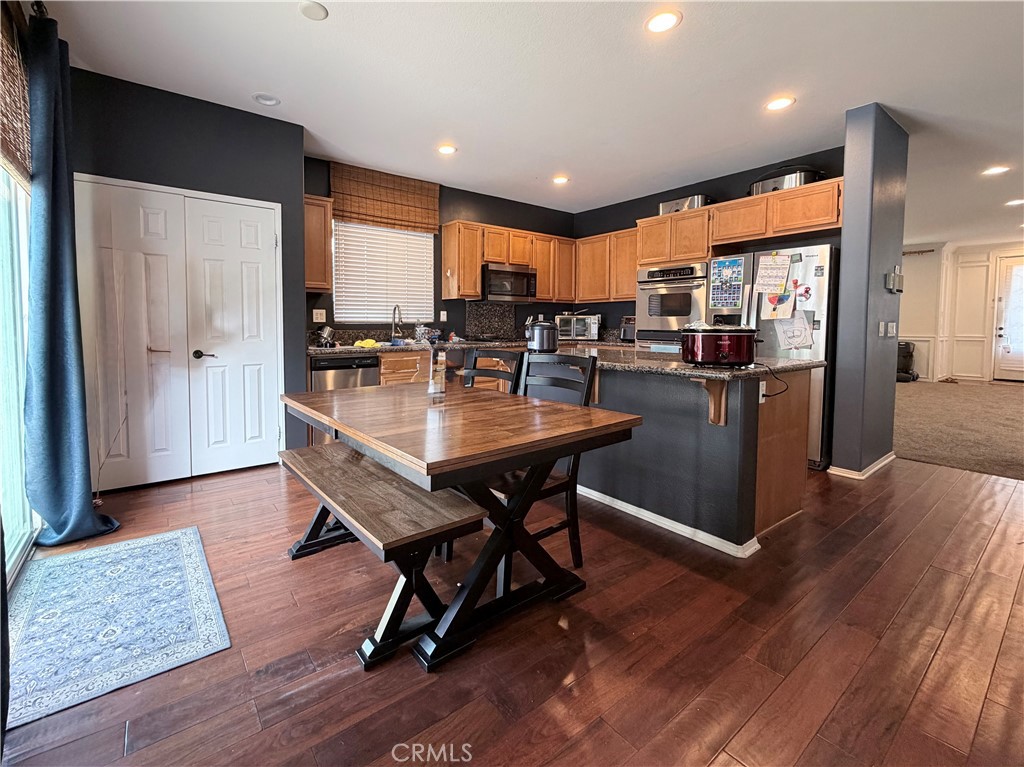 562 Quigley Lane Perris, CA 92570 - Photo 6 of 29 a kitchen with a table chairs refrigerator and cabinets