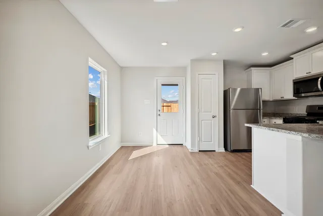 a kitchen with a refrigerator and a stove top oven