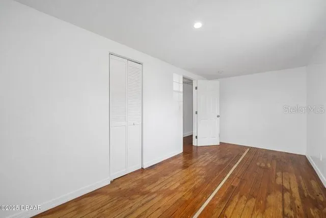 a view of a room with wooden floor and white walls