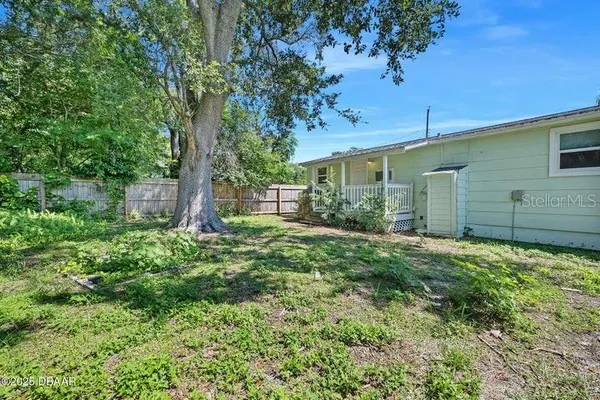 a backyard of a house with plants and tree