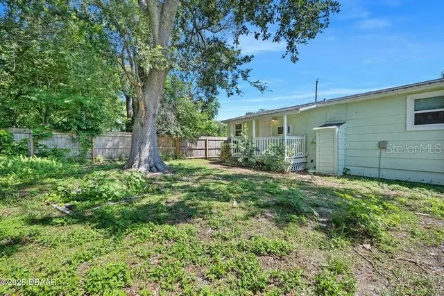 a backyard of a house with plants and tree