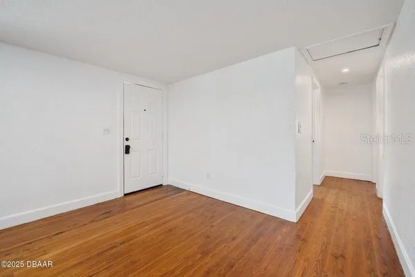 a view of an empty room with wooden floor
