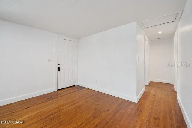 a view of an empty room with wooden floor