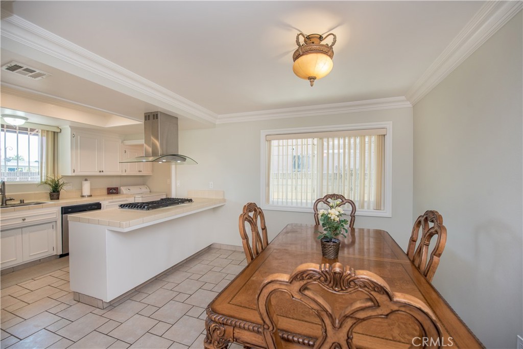 4459 Pine Street Pico Rivera, CA 90660 - Photo 5 of 38 a kitchen with stainless steel appliances granite countertop a stove a sink a dining table and chairs with wooden floor