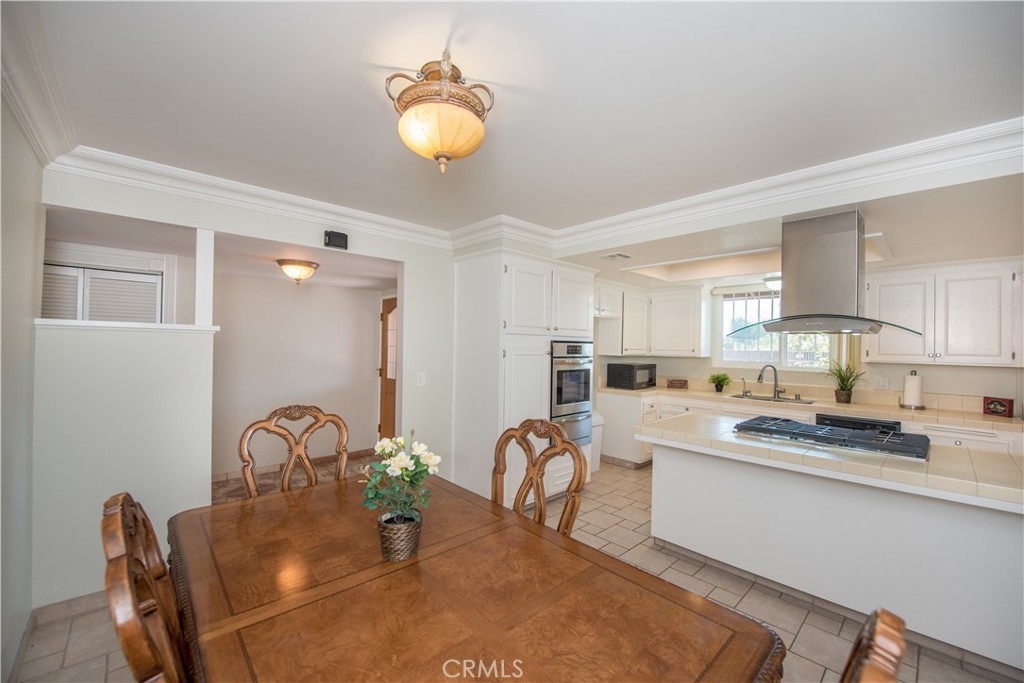 4459 Pine Street Pico Rivera, CA 90660 - Photo 6 of 38 a kitchen with stainless steel appliances granite countertop a stove a sink dishwasher and white cabinets with wooden floor
