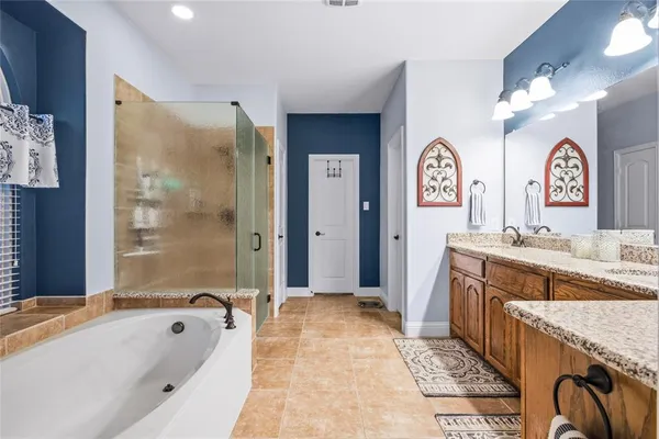 a spacious bathroom with a tub sink and mirror