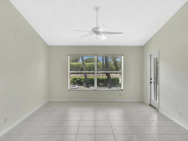 a view of an empty room and a kitchen