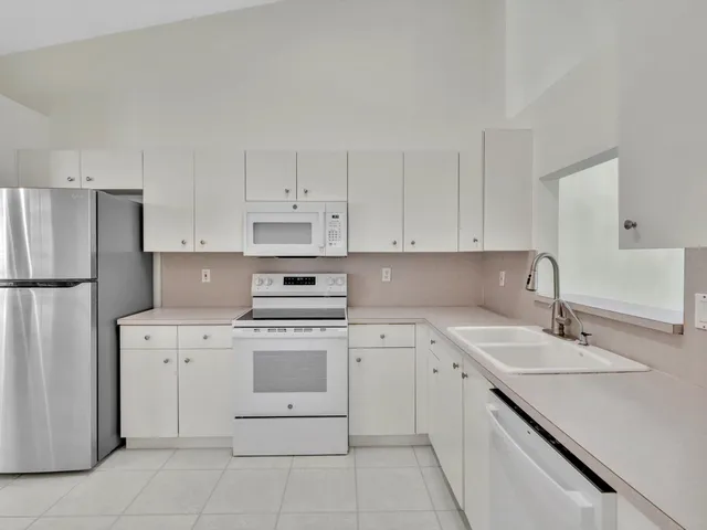 a kitchen with cabinets appliances and a sink