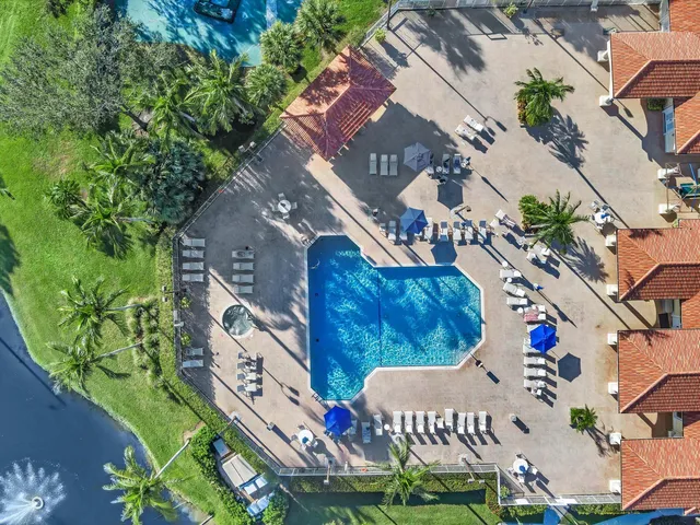 an aerial view of residential house with yard and swimming pool