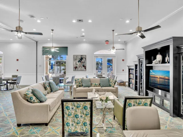 a living room with lots of furniture and a ceiling fan