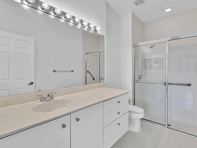 a bathroom with a granite countertop sink a toilet and shower