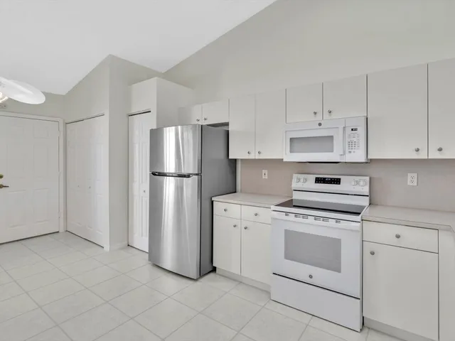 a kitchen with cabinets stainless steel appliances and a counter space