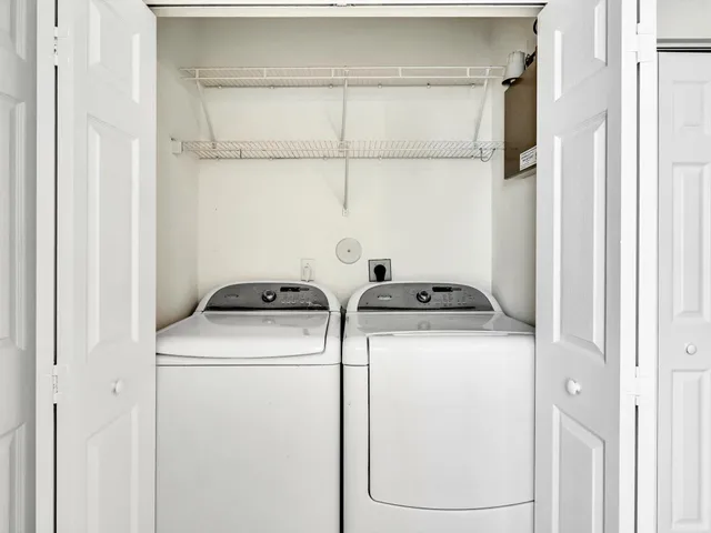 a kitchen with white cabinets appliances and a window