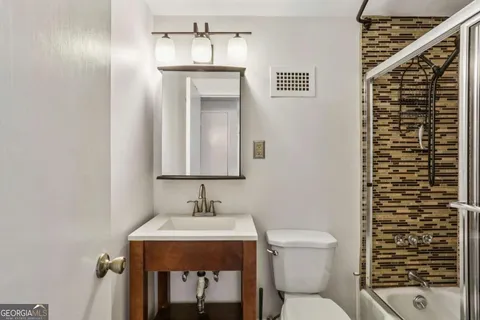a bathroom with a toilet a sink and mirror