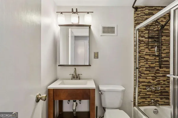 a bathroom with a toilet a sink and mirror