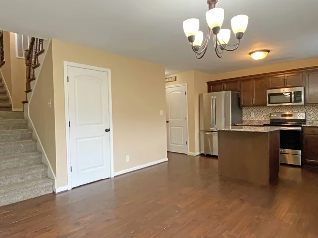 a view of kitchen with stainless steel appliances granite countertop cabinets and wooden floor