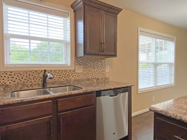 a kitchen with granite countertop a sink and a window