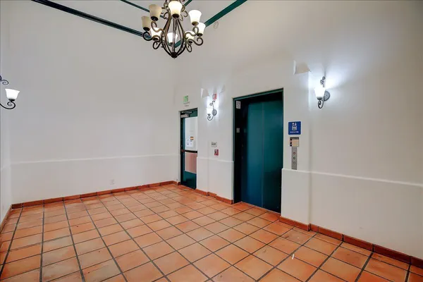 a view of a hallway with wooden floor and chandelier
