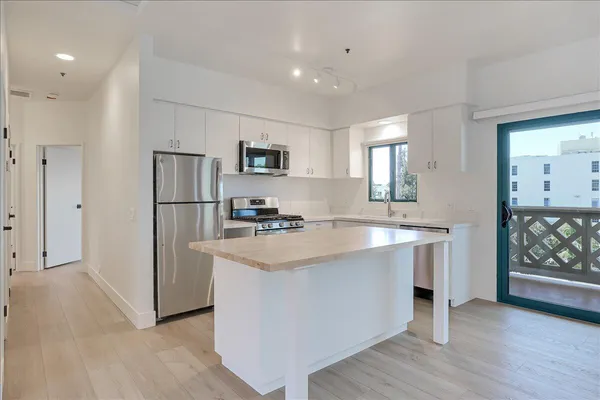 a kitchen with kitchen island a sink stove and refrigerator