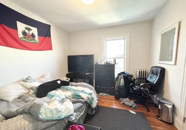 a bedroom with furniture and a flat screen tv