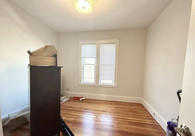 a view of a livingroom with wooden floor and a window